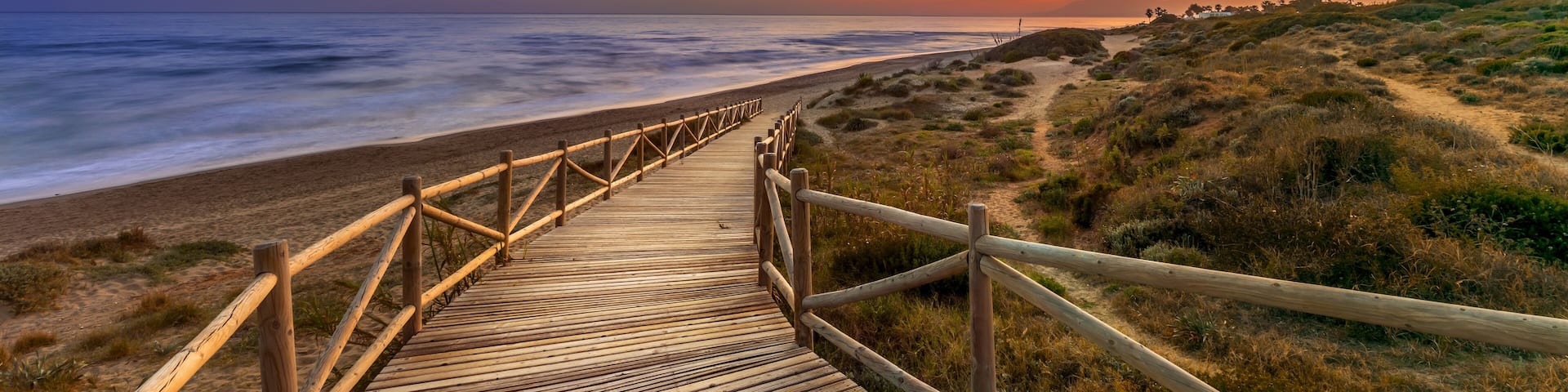 Bright sunset sky over sea and timber path
