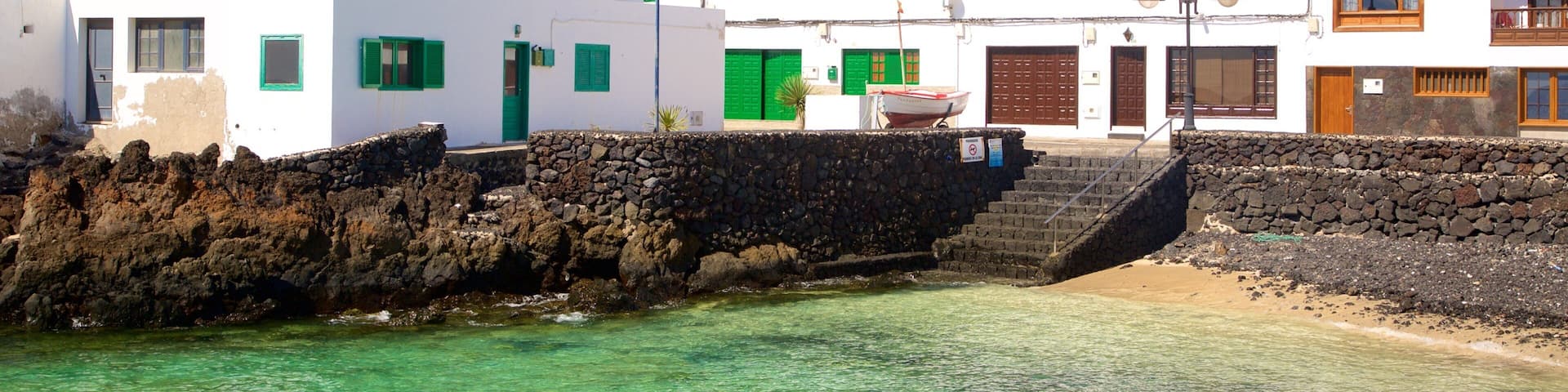 Lanzarote which includes general coastal views, a coastal town and rocky coastline