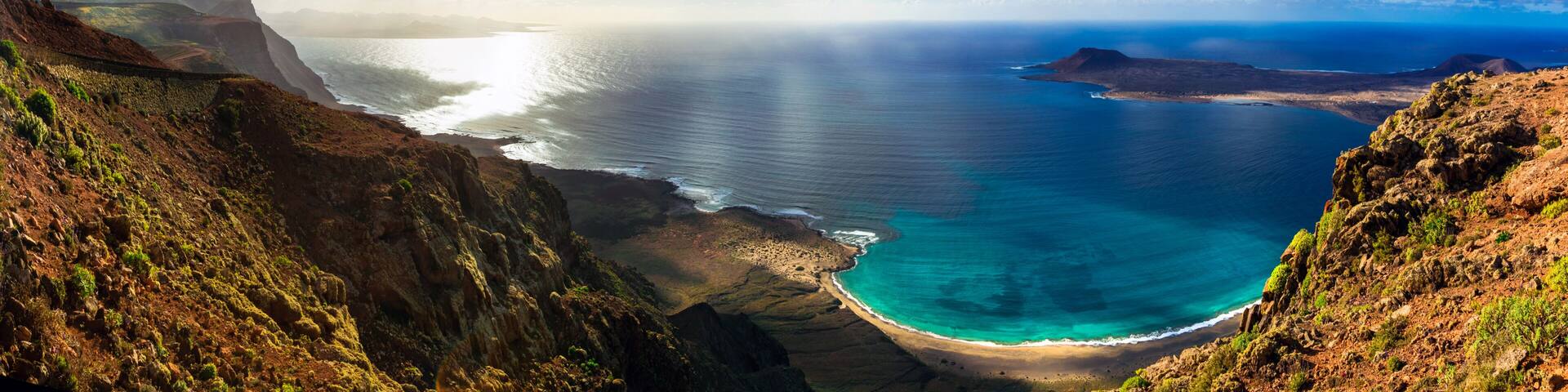Breathtaking 12K Panorama of Turquoise Ocean Bay and Graciosa Island at Sunset Golden Hour Light from Mirador del Rio Lanzarote Canary Islands Spain Scenic Volcanic Landscape