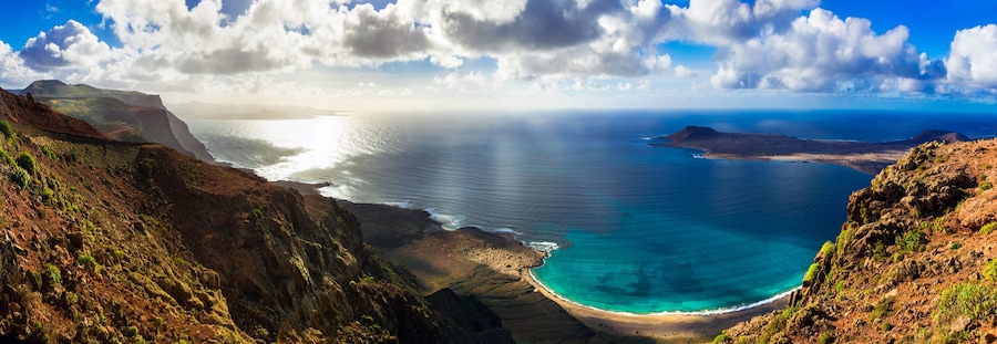 Breathtaking 12K Panorama of Turquoise Ocean Bay and Graciosa Island at Sunset Golden Hour Light from Mirador del Rio Lanzarote Canary Islands Spain Scenic Volcanic Landscape