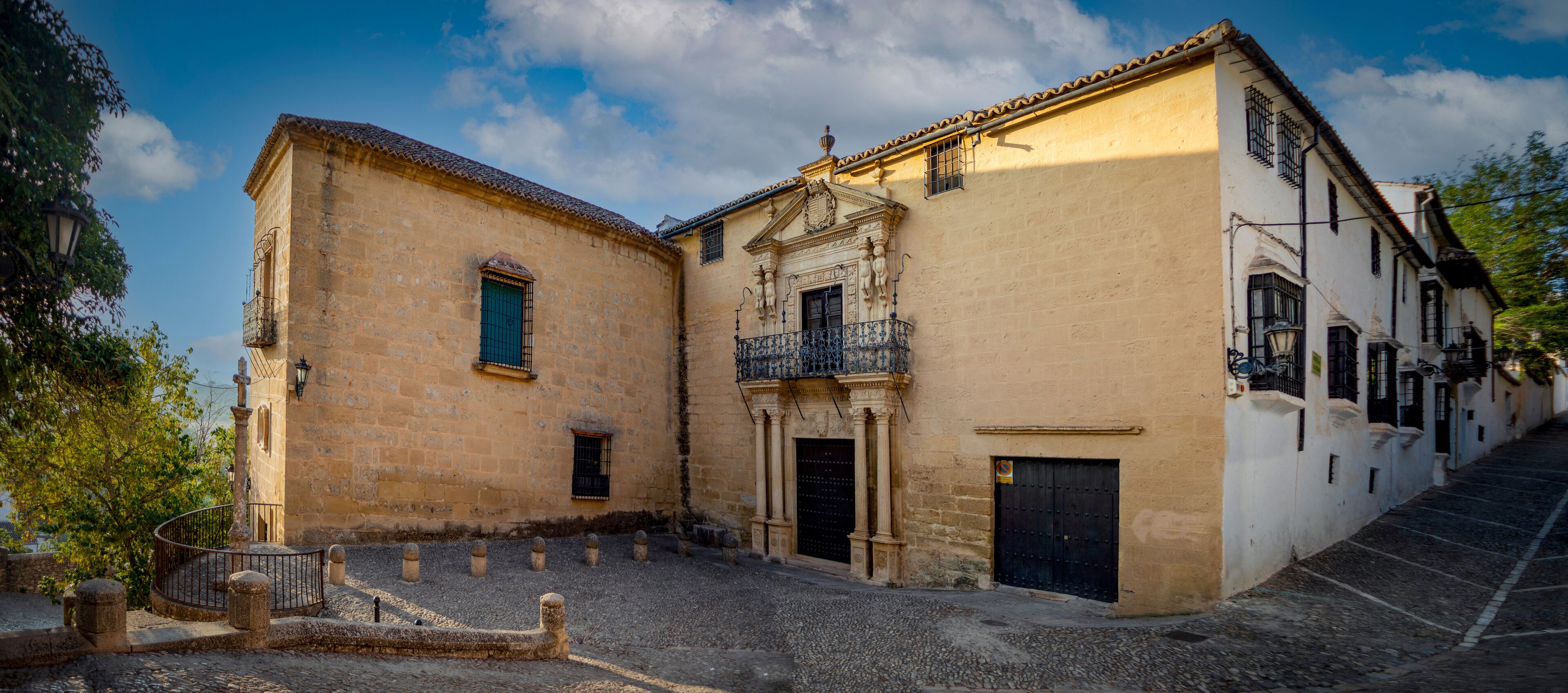 A historic building with a balcony and a cobblestone street.