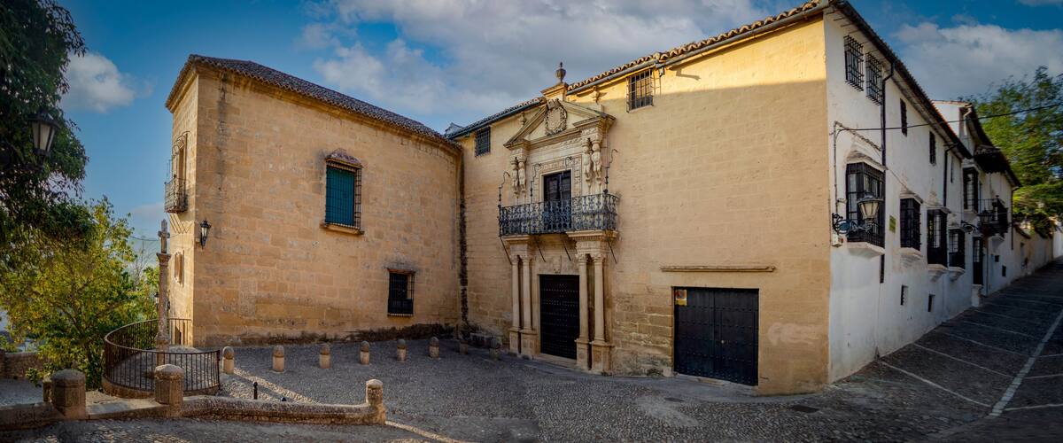 A historic building with a balcony and a cobblestone street.