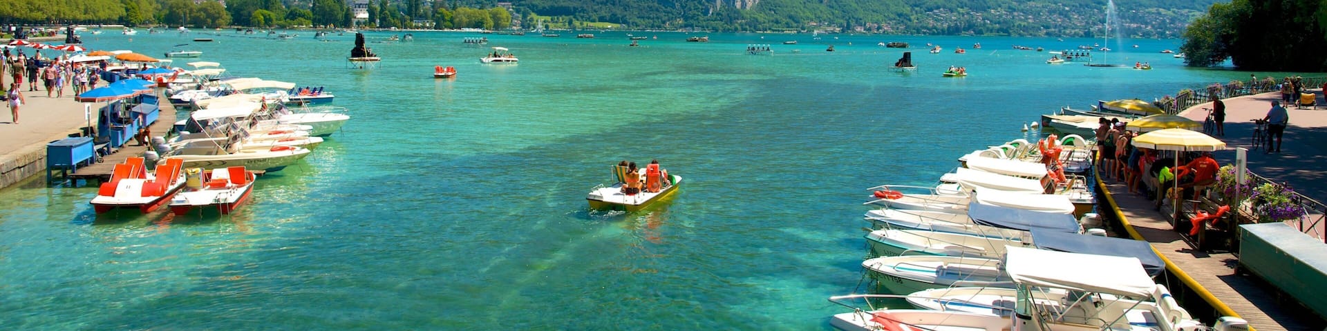 Lake Annecy which includes mountains, a bay or harbor and boating