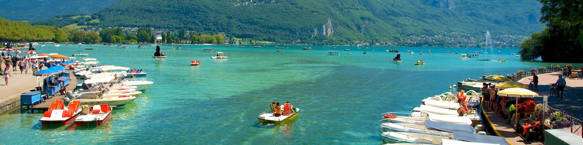 Lake Annecy which includes mountains, a bay or harbor and boating