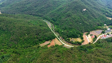 Aerial Drone Footage of Rugged Mountain Terrain and Lush Forest Slopes in Mungyeong, Korea – Scenic Nature and Rock Formations