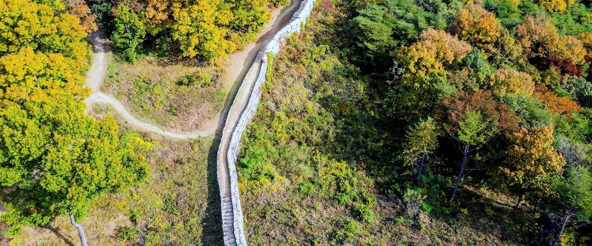 Aerial view of Gomosan fortress wall and gate house in South Korea on sunny fall day.