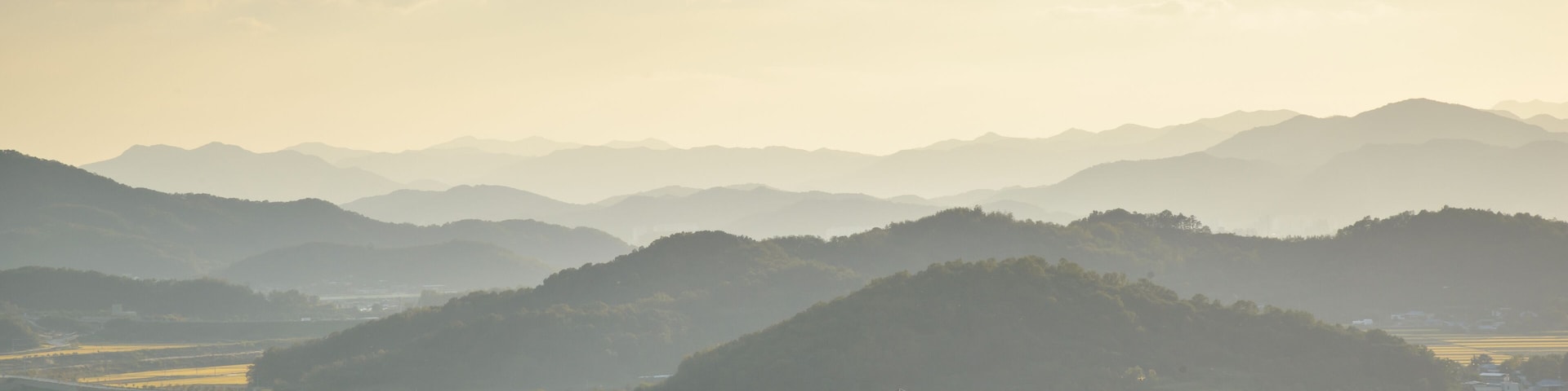 Paisagem montanhosa com um vale e um rio.