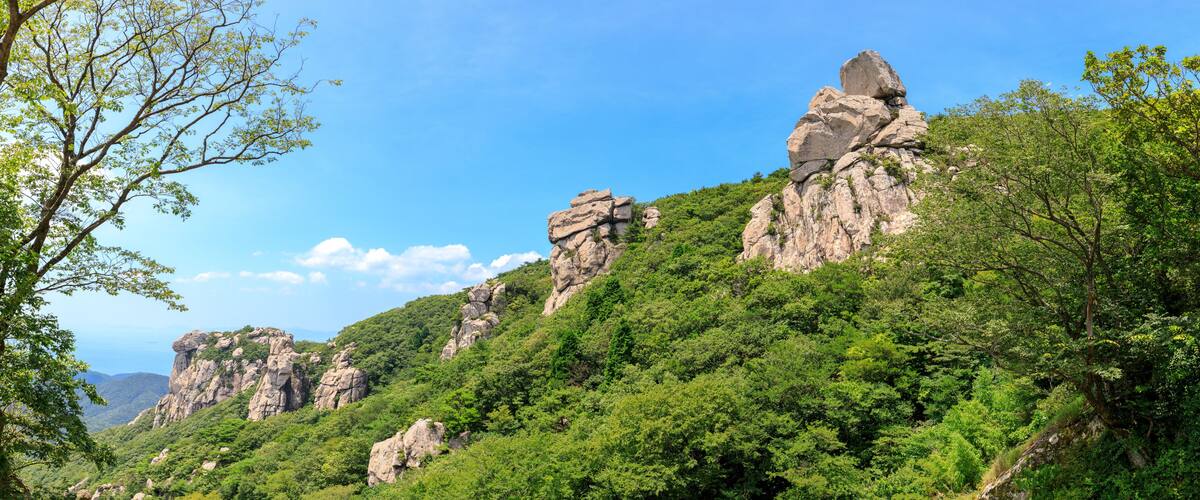 A mountainous landscape with rocky outcrops and dense green foliage.