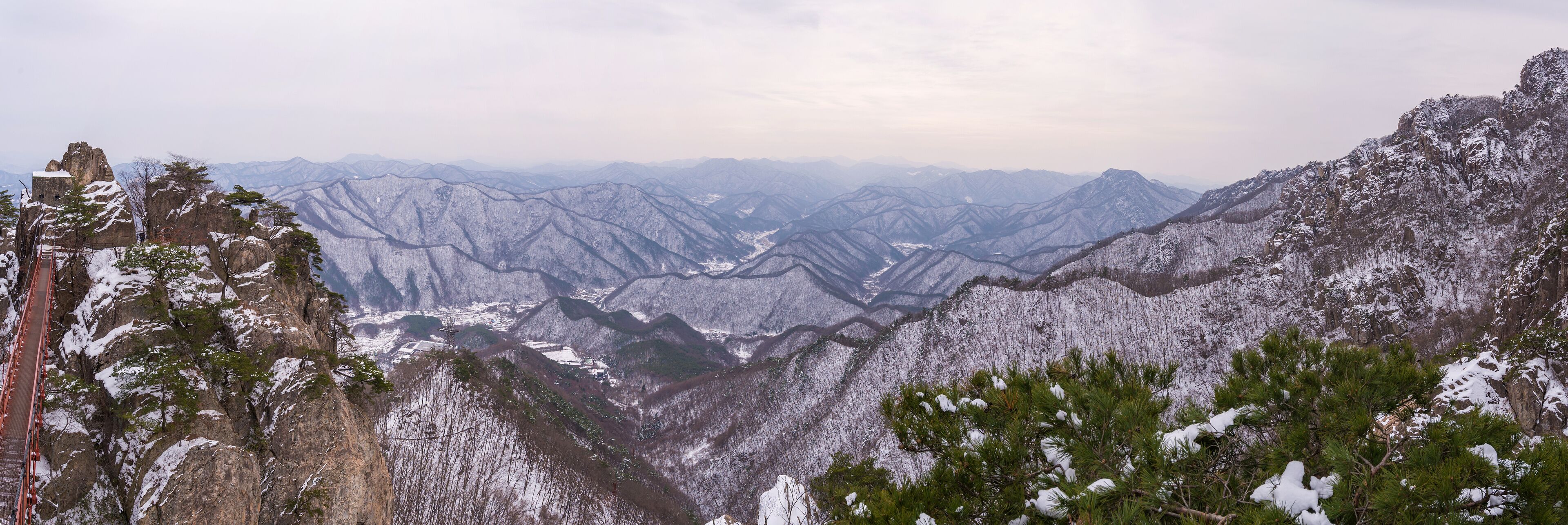 A snow-covered mountain range with a bridge.