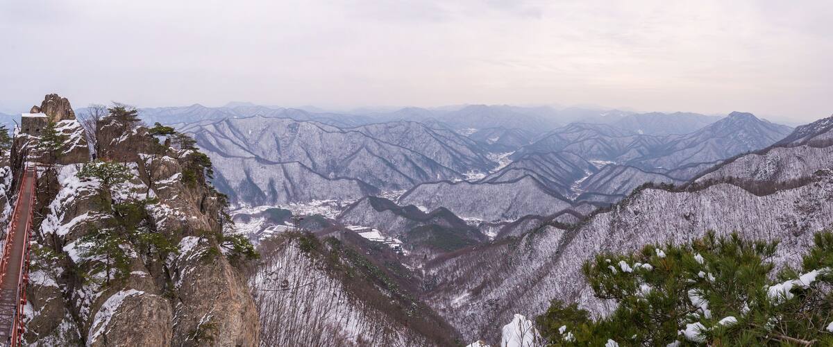 A snow-covered mountain range with a bridge.