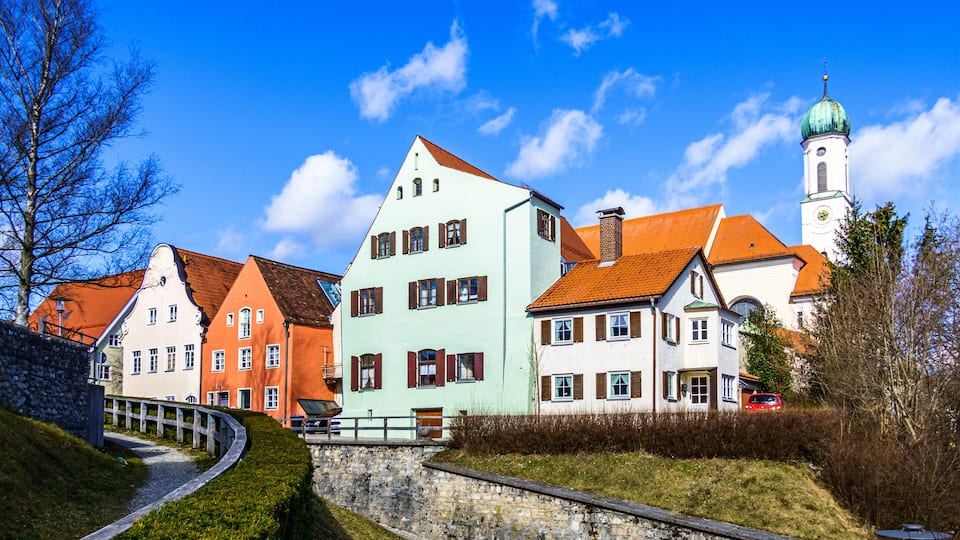 A row of colorful buildings with a church tower in the background.