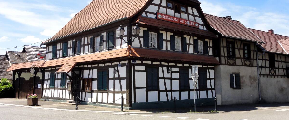 A traditional half-timbered building with a sign reading "RESTAURANT AU SOLEIL".