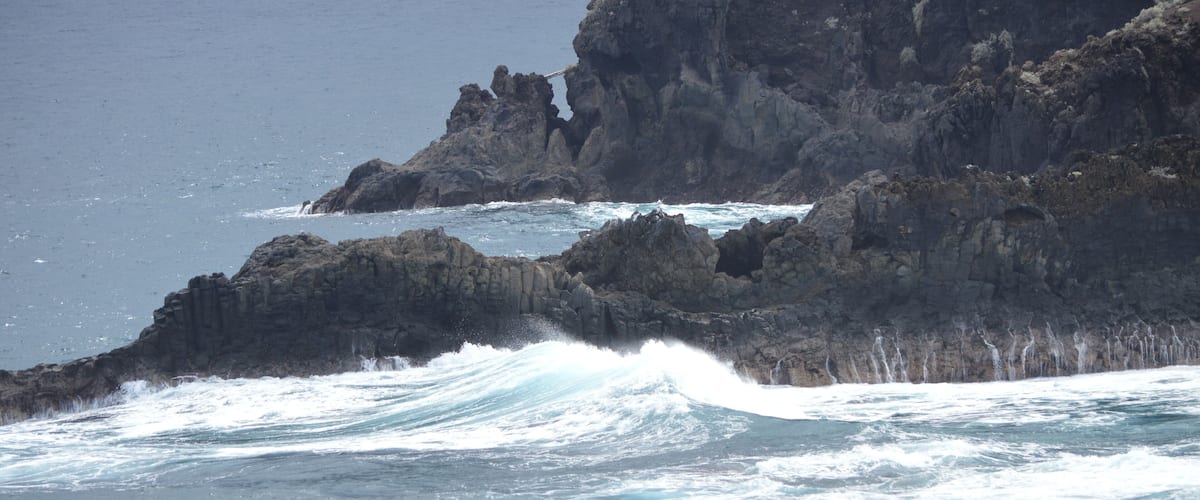A rocky coastline with waves crashing against the rocks.