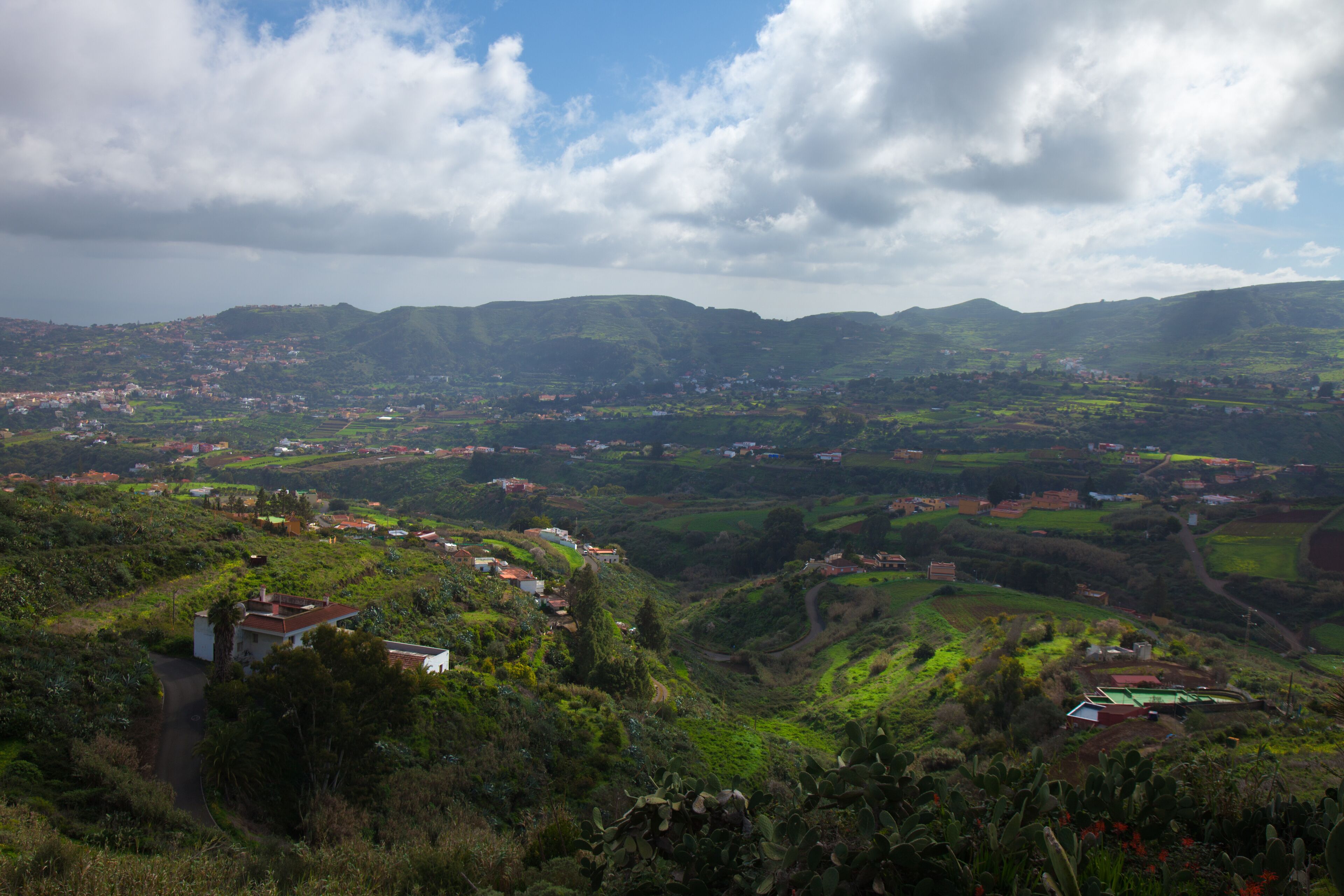 A mountainous landscape with scattered houses and greenery.