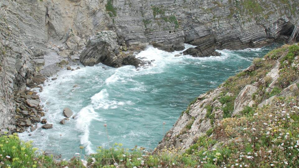A coastal cliff with a turbulent sea.