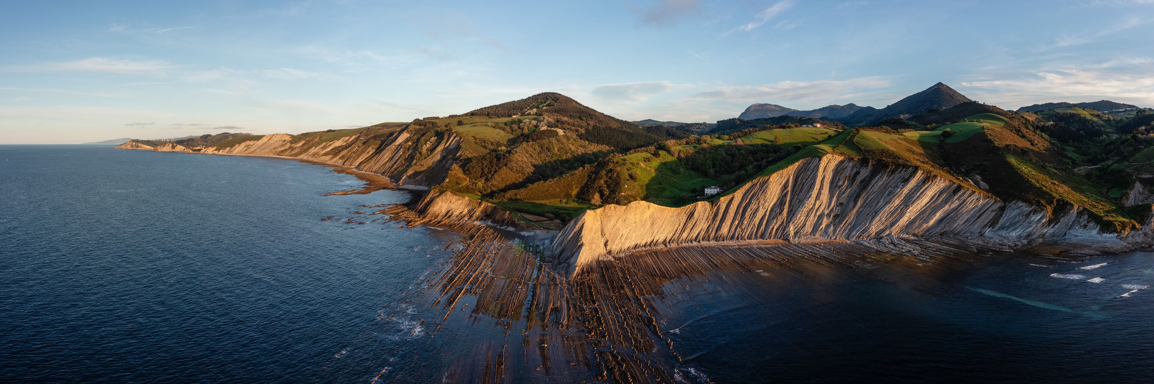 A coastal landscape with cliffs and a beach.