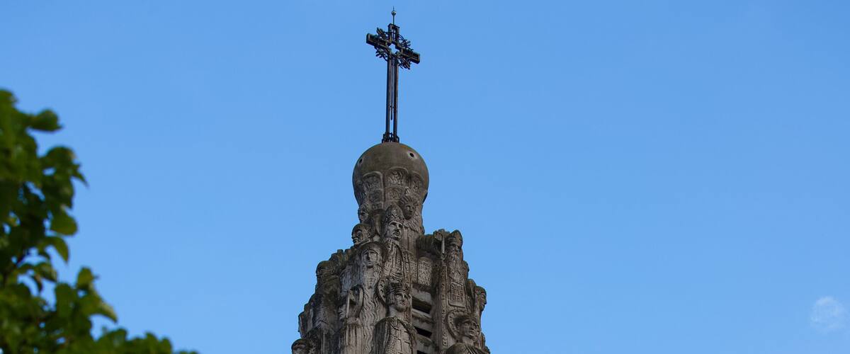 A tall tower with a clock and a weather vane.