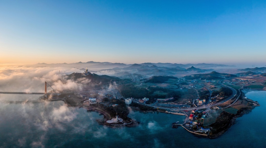 Aerial and panoramic view of sun rising over sea of clouds on Jindo Bridge and Uldolmok at Nokjin-ri near Jindo-gun, South Korea