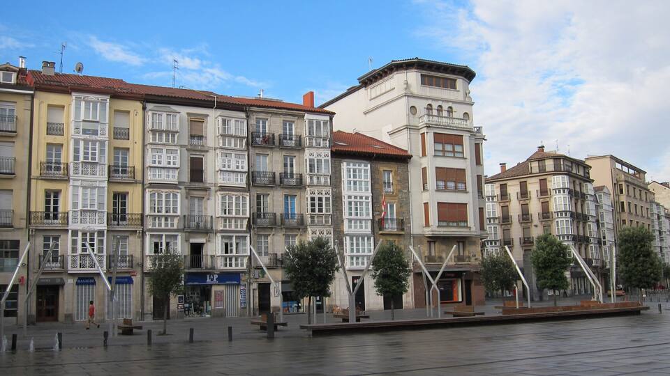 Une rangée de bâtiments historiques dotés de balcons richement décorés, avec une rivière au premier plan.