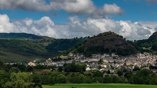 Panoramic view of Murat , beautiful village in the French region of Cantal with staue of the virgin mary .