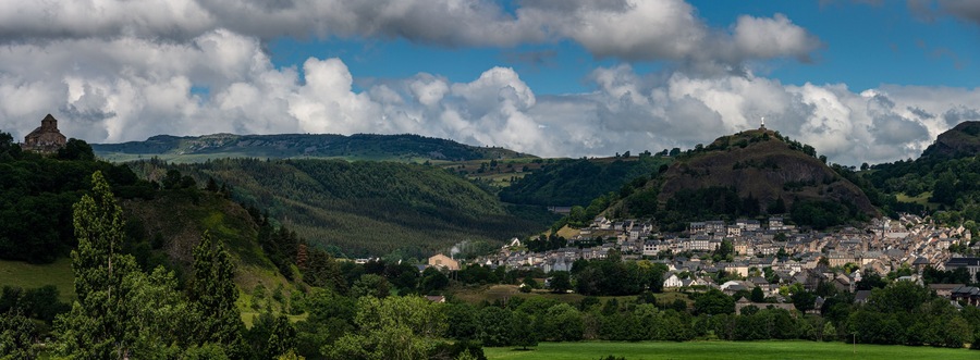 Panoramic view of Murat , beautiful village in the French region of Cantal with staue of the virgin mary .