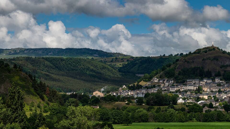 Panoramic view of Murat , beautiful village in the French region of Cantal with staue of the virgin mary .