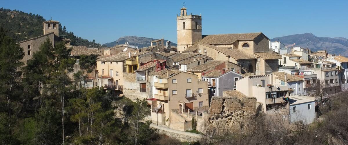 A hillside village with historic buildings and a prominent tower.