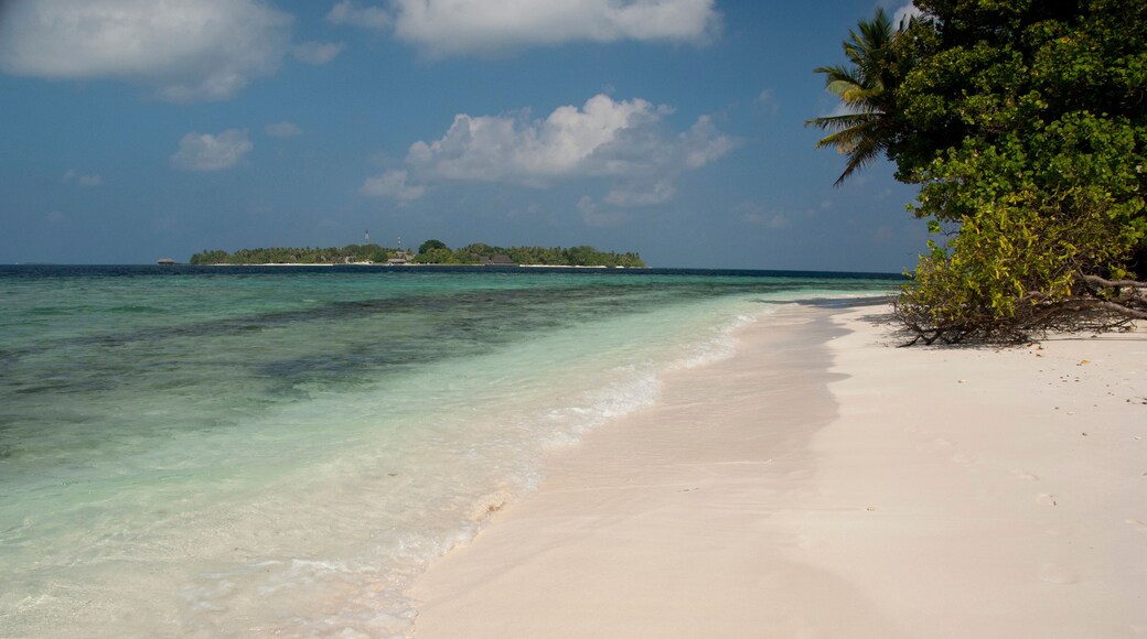 Maldives, North Male Atoll, Island of Kuda Bandos. View of the resort island of Bandos from the white sand beach of adjacent island.