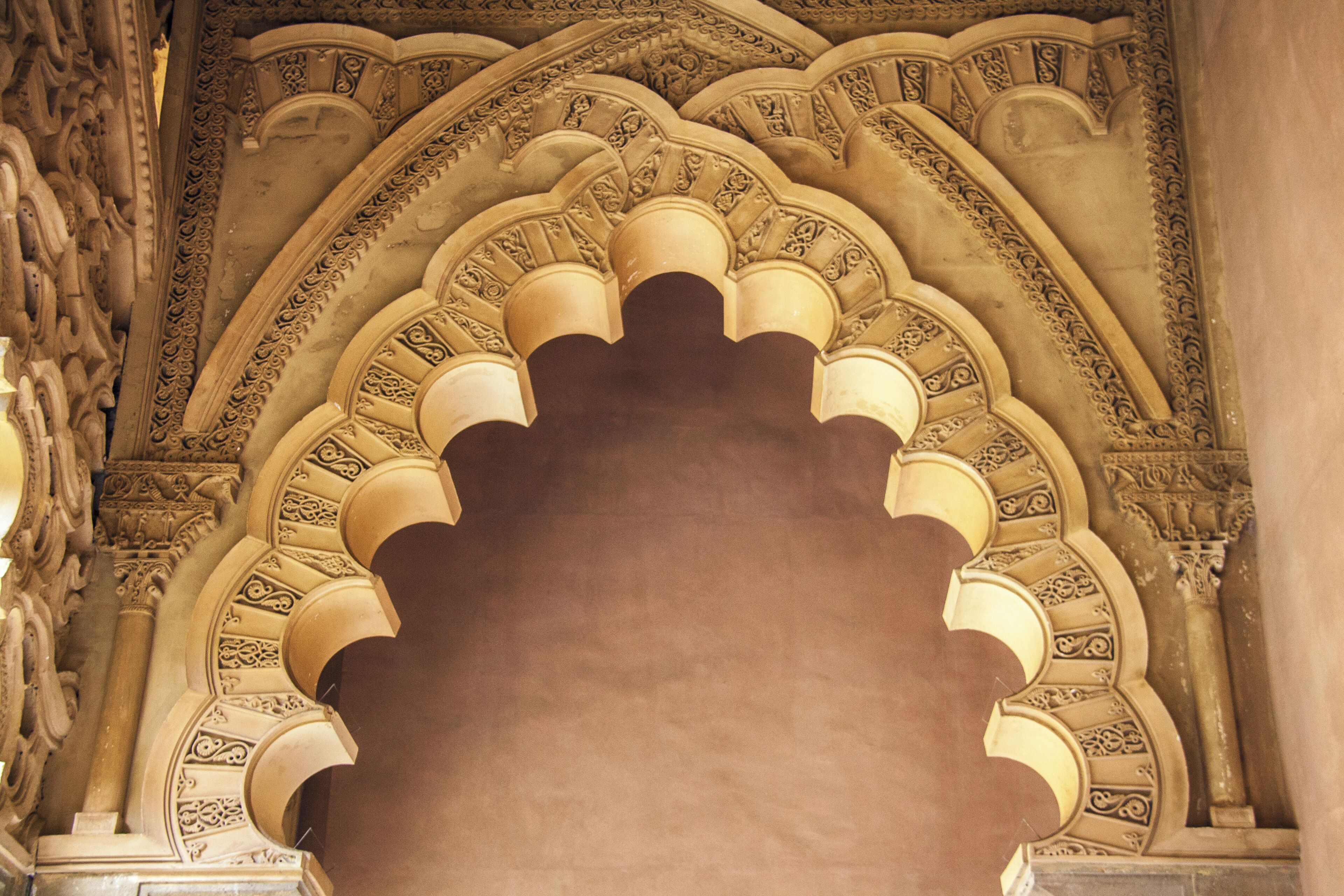 Un arc monumental, richement décoré de sculptures complexes, et composé d’une série d’arches.