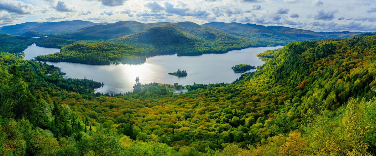 A lake surrounded by forested hills and mountains.