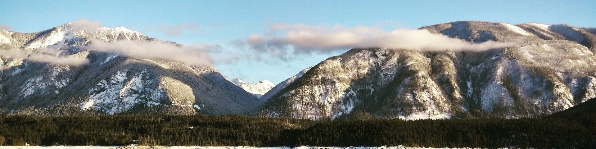 Um lago com montanhas ao fundo.