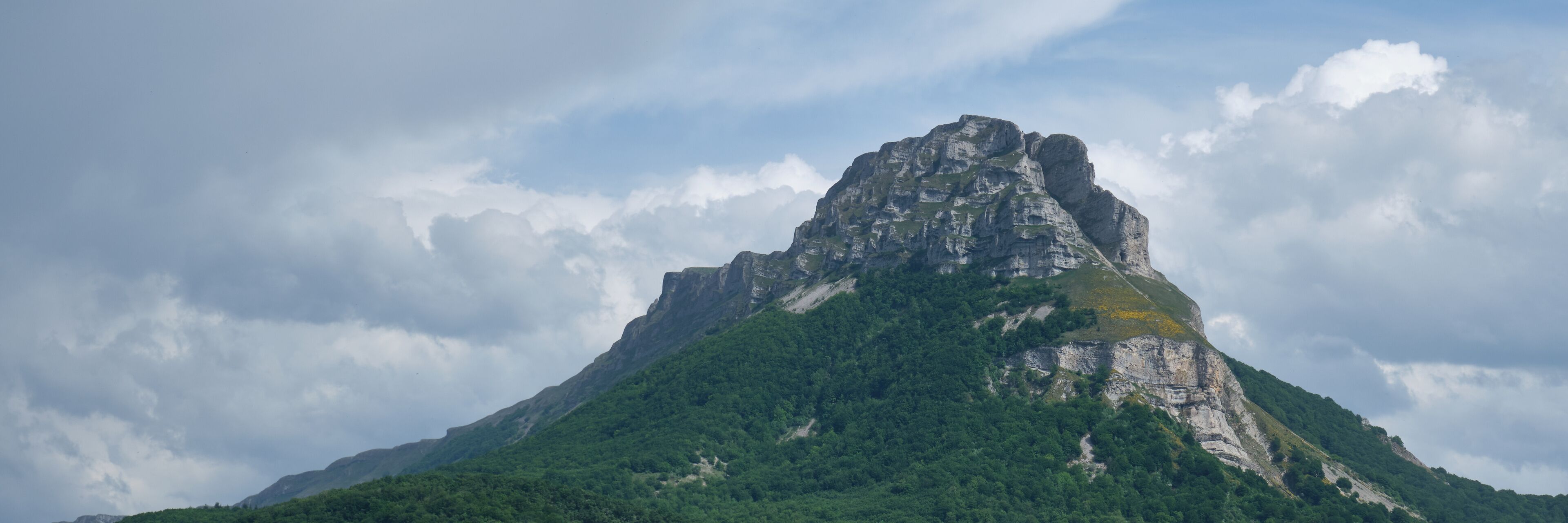A mountain with a prominent peak and lush green vegetation.