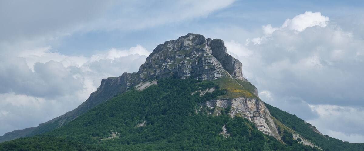 A mountain with a prominent peak and lush green vegetation.