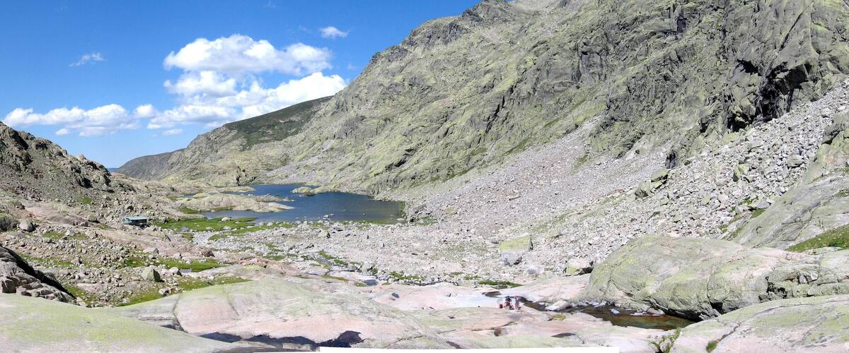 A rocky valley with a small lake surrounded by steep mountains.