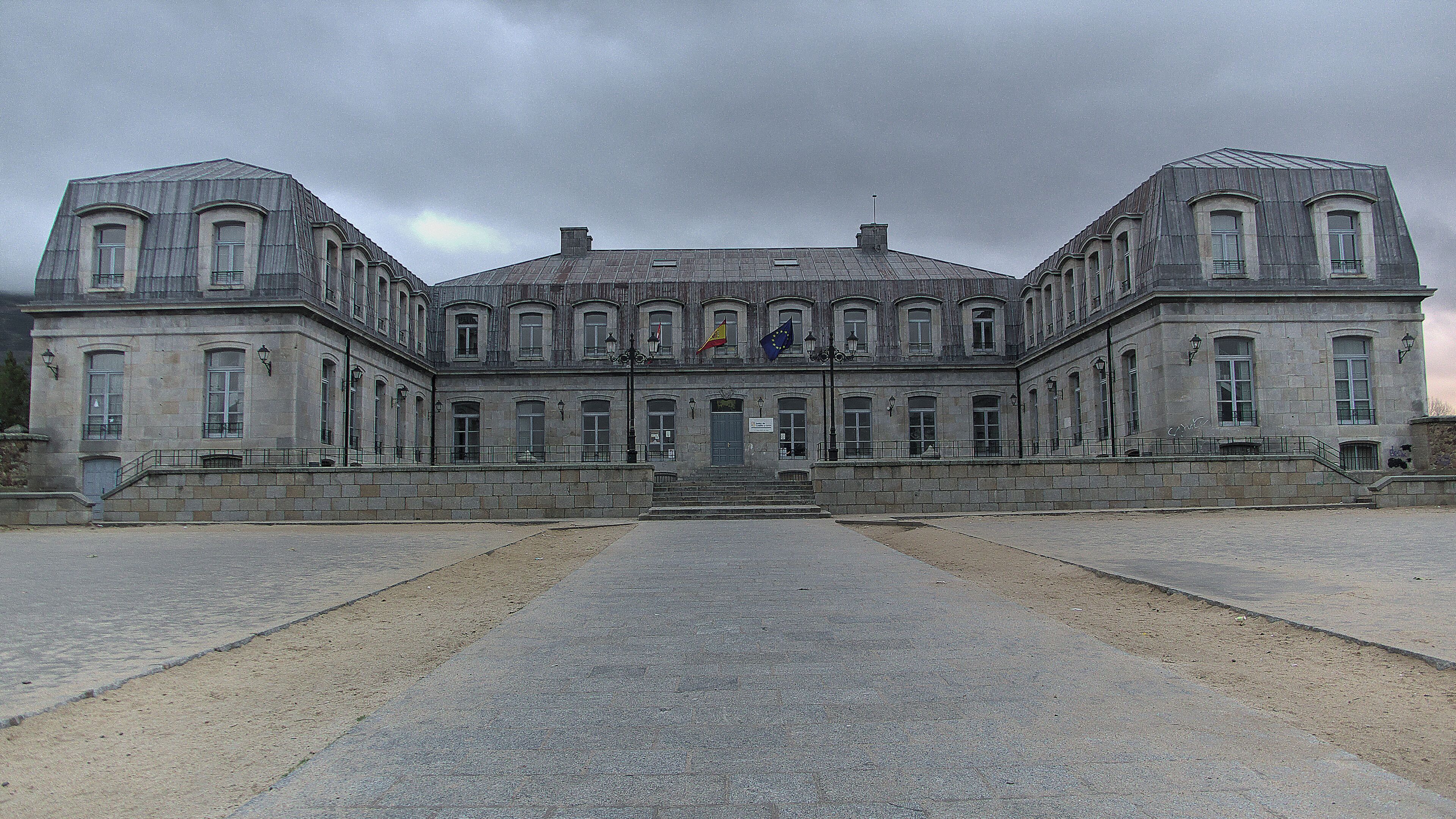 A large, historic building with symmetrical architecture, featuring a central entrance and multiple windows.