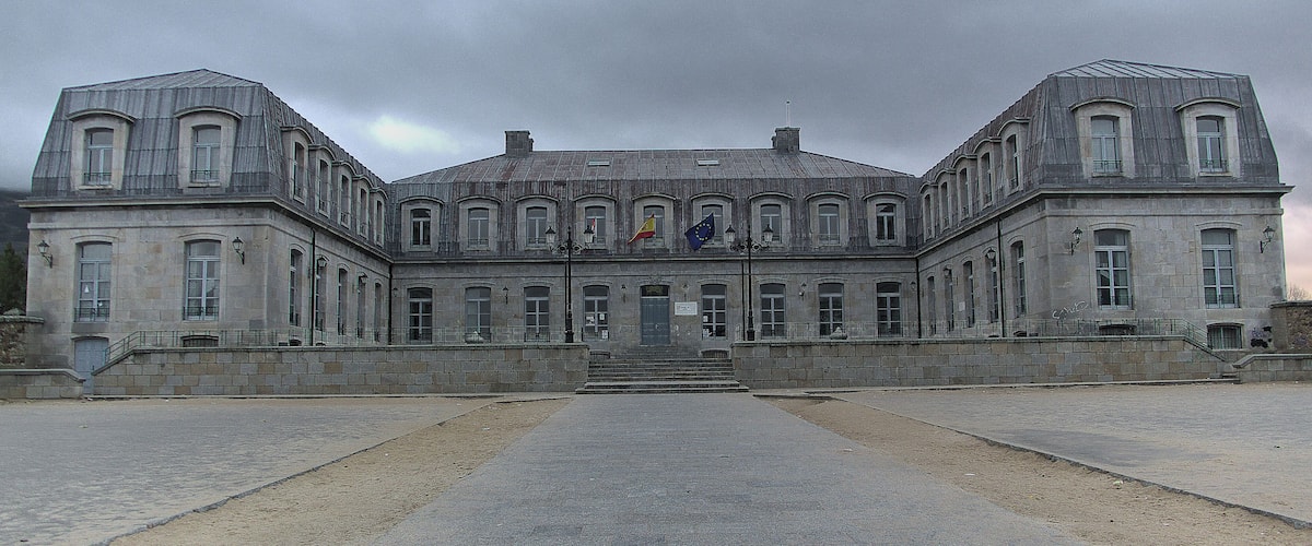 A large, historic building with symmetrical architecture, featuring a central entrance and multiple windows.