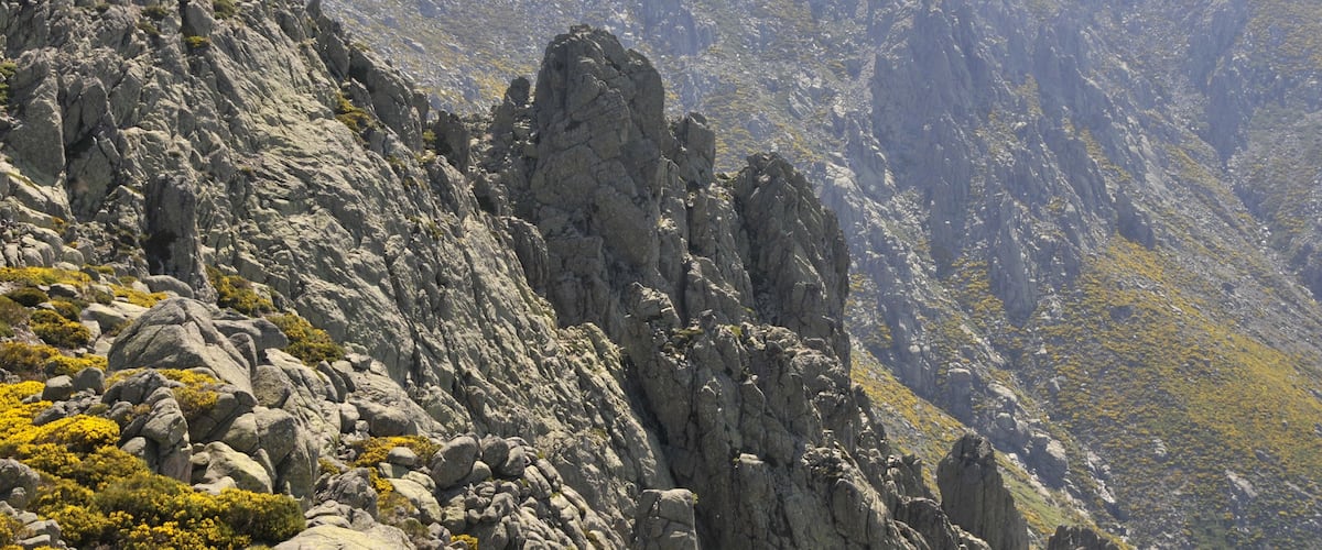 A rugged mountain landscape with rocky outcrops and sparse vegetation.