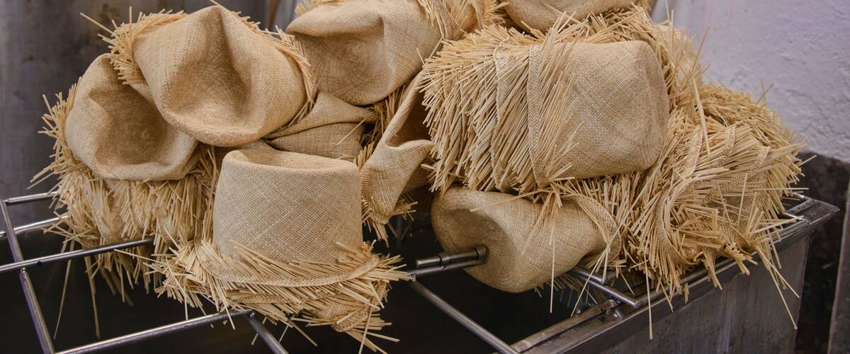 Burlap sacks filled with straw, stacked on a metal rack.