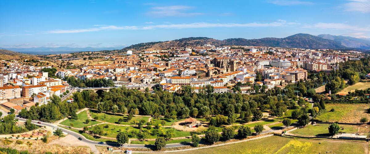 A cityscape with a prominent cathedral, a large park, and surrounding hills.