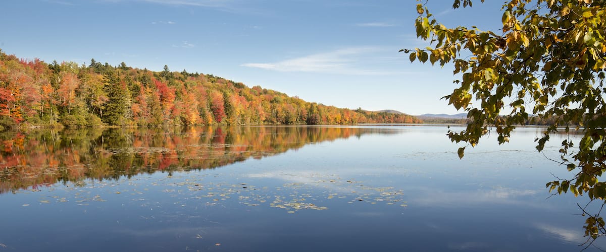 A calm lake surrounded by autumn-colored trees.