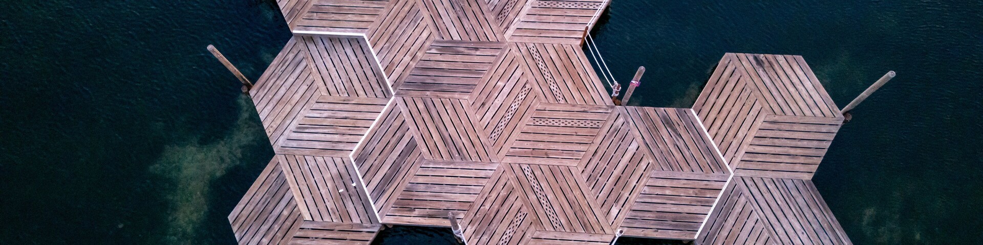 Una estructura de madera hexagonal que se adentra en una masa de agua.