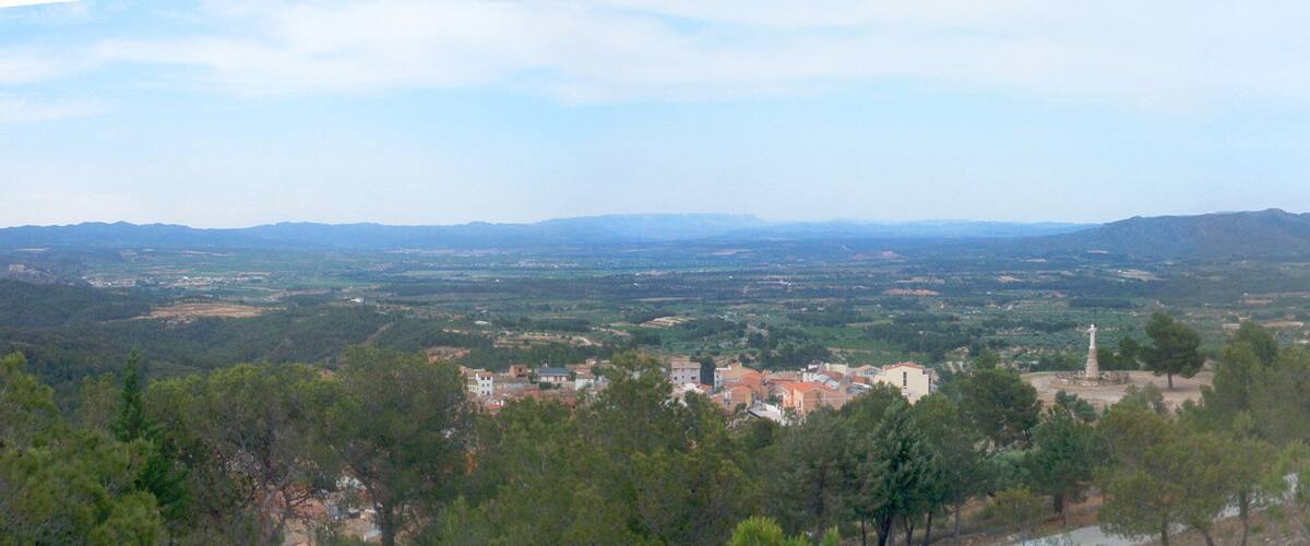 A mountainous landscape with a village nestled among trees.