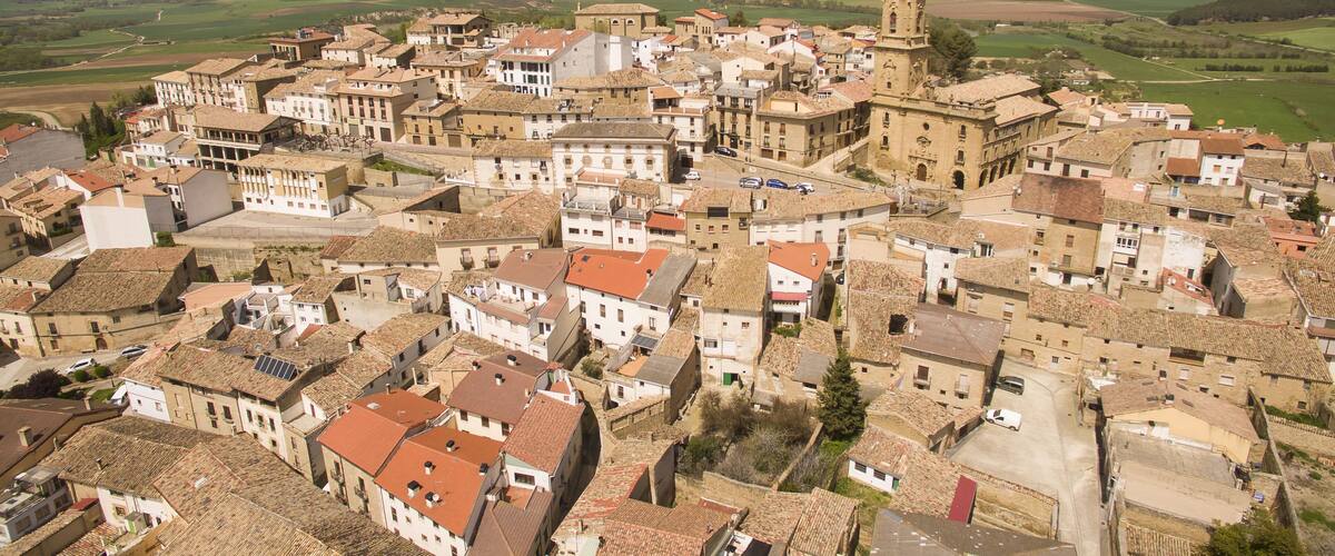 A historic town with a prominent church tower and surrounding buildings.