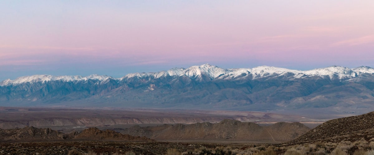 A mountain range with snow-capped peaks and a barren landscape.