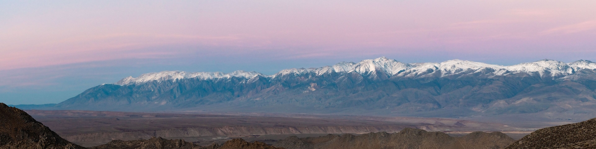 A mountain range with snow-capped peaks and a barren landscape.