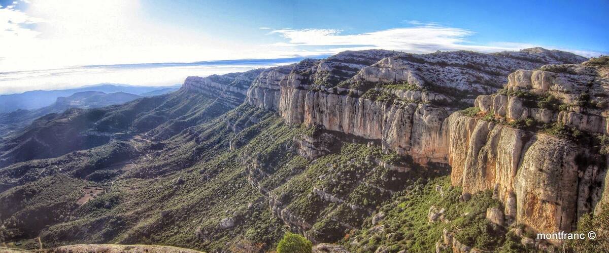 A mountainous landscape with steep cliffs and sparse vegetation.