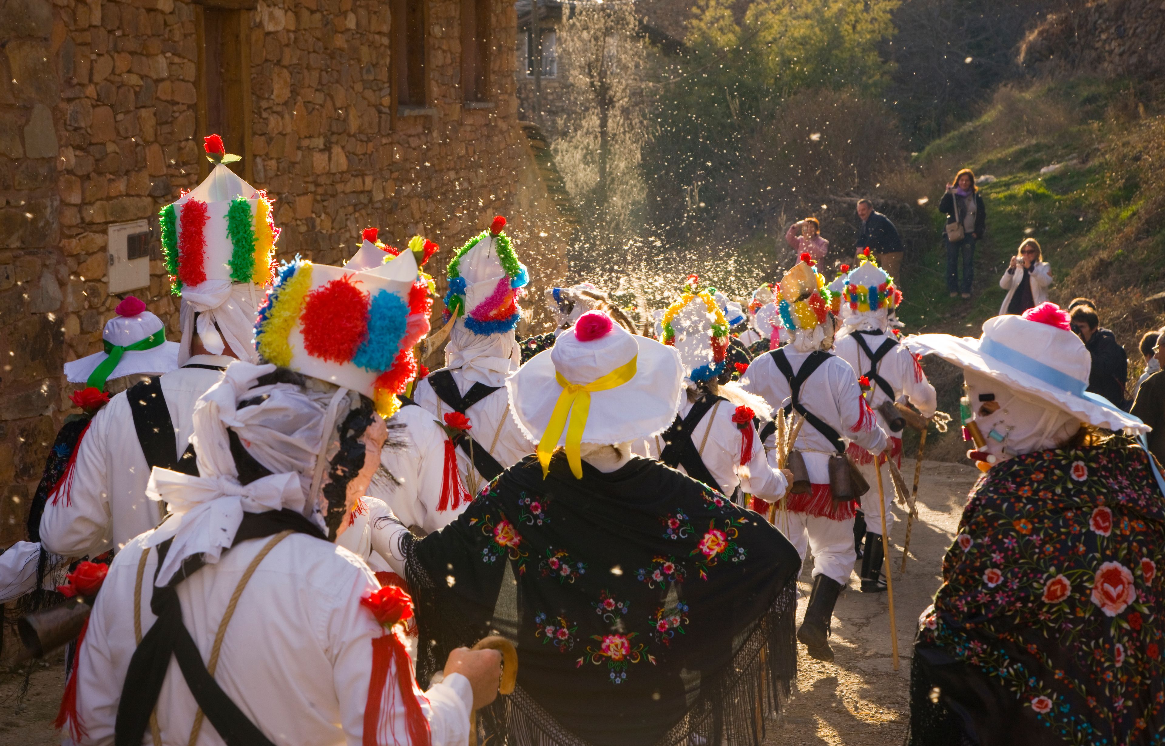A group of people in traditional attire walking down a street.