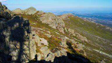 A rugged mountain landscape with rocky outcrops and sparse vegetation.