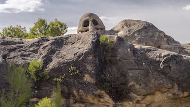 Un paisaje rocoso con grandes rocas y una formación rocosa destacada, con una abertura similar a una cueva.