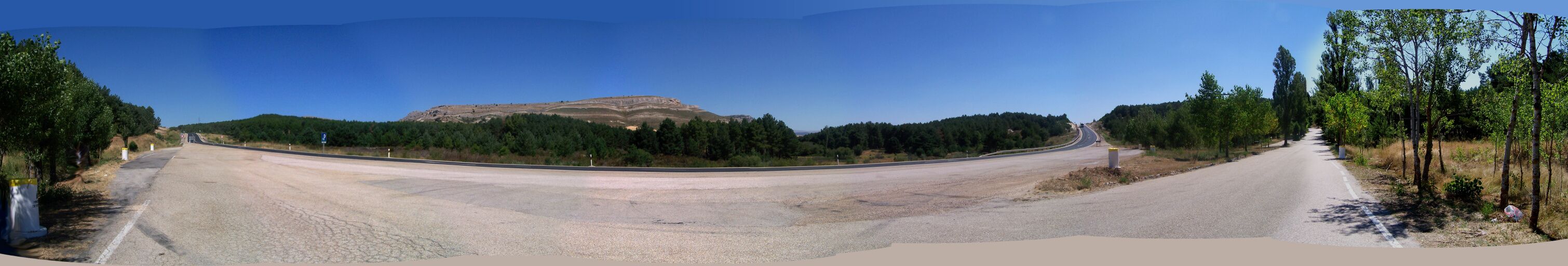 A winding road with a mountain in the background.